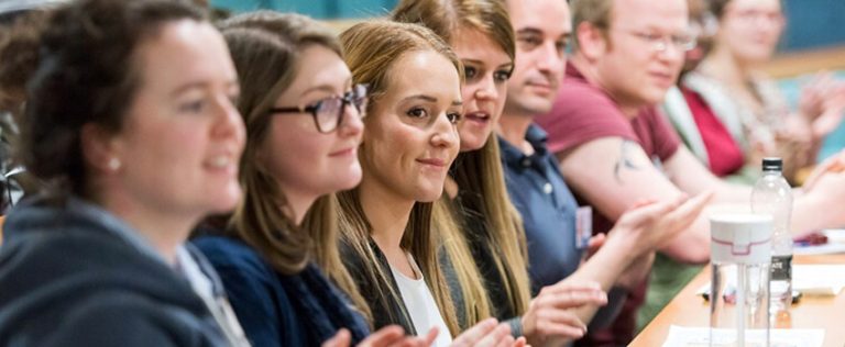 Group of students applauding in a classroom, representing engagement in HND courses.