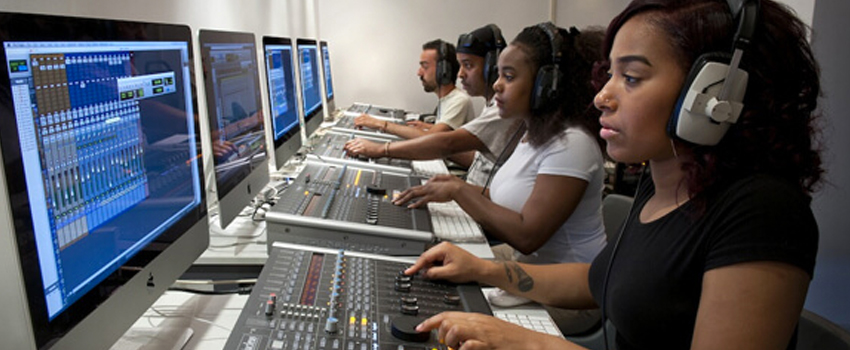Students working on audio equipment in a lab, representing hands-on learning in HND courses.