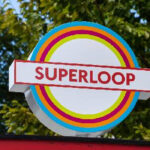 A colorful circular Superloop sign with bold red lettering