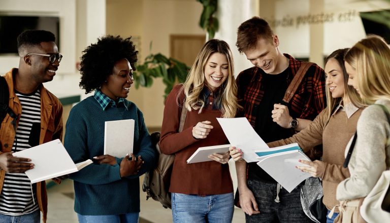 A group of cheerful students reviewing documents, showcasing how to elevate your career with an HND qualification.