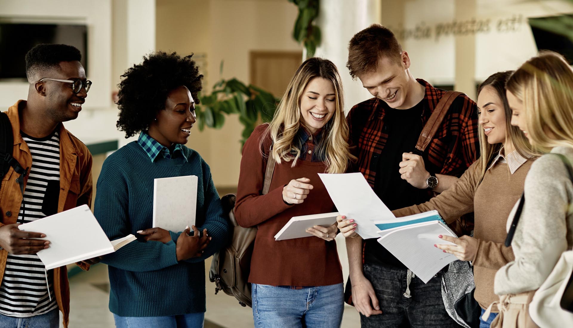 A group of cheerful students reviewing documents, showcasing how to elevate your career with an HND qualification.