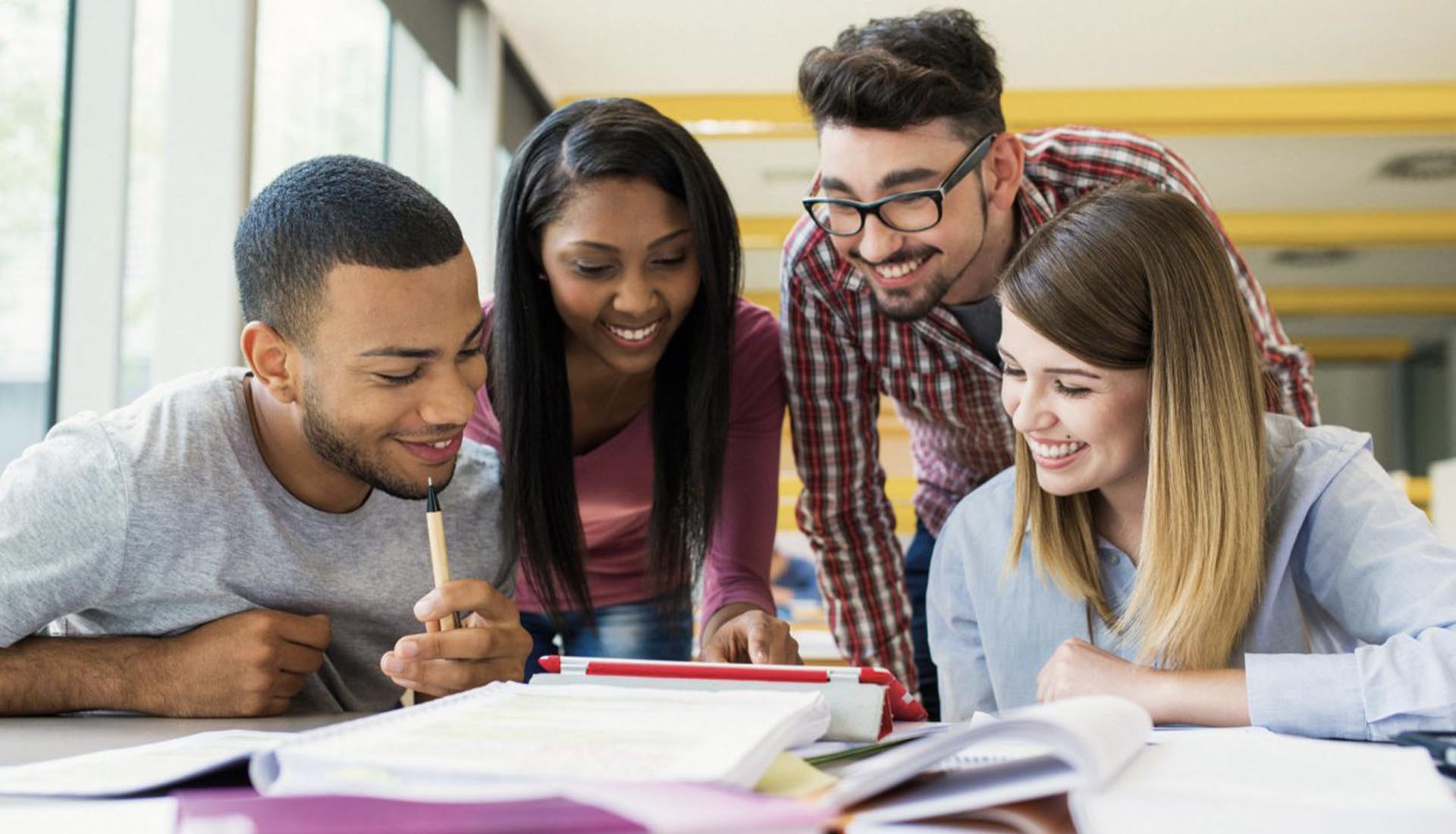 A group of students collaborating over study materials, highlighting how to elevate your career with an HND qualification.