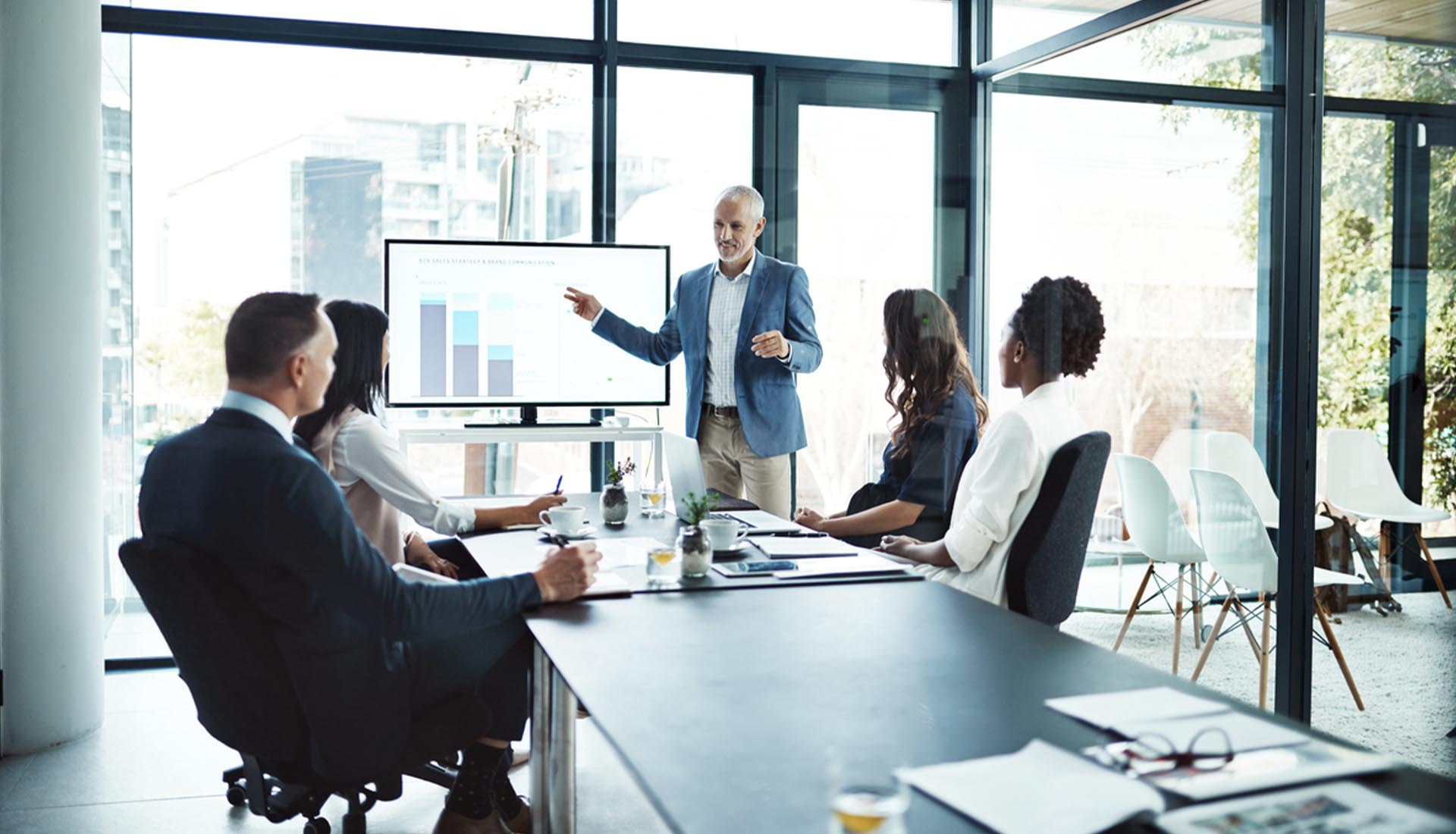 A professional presenting data on a screen to colleagues in a modern office, highlighting HND and career pathways opportunities.