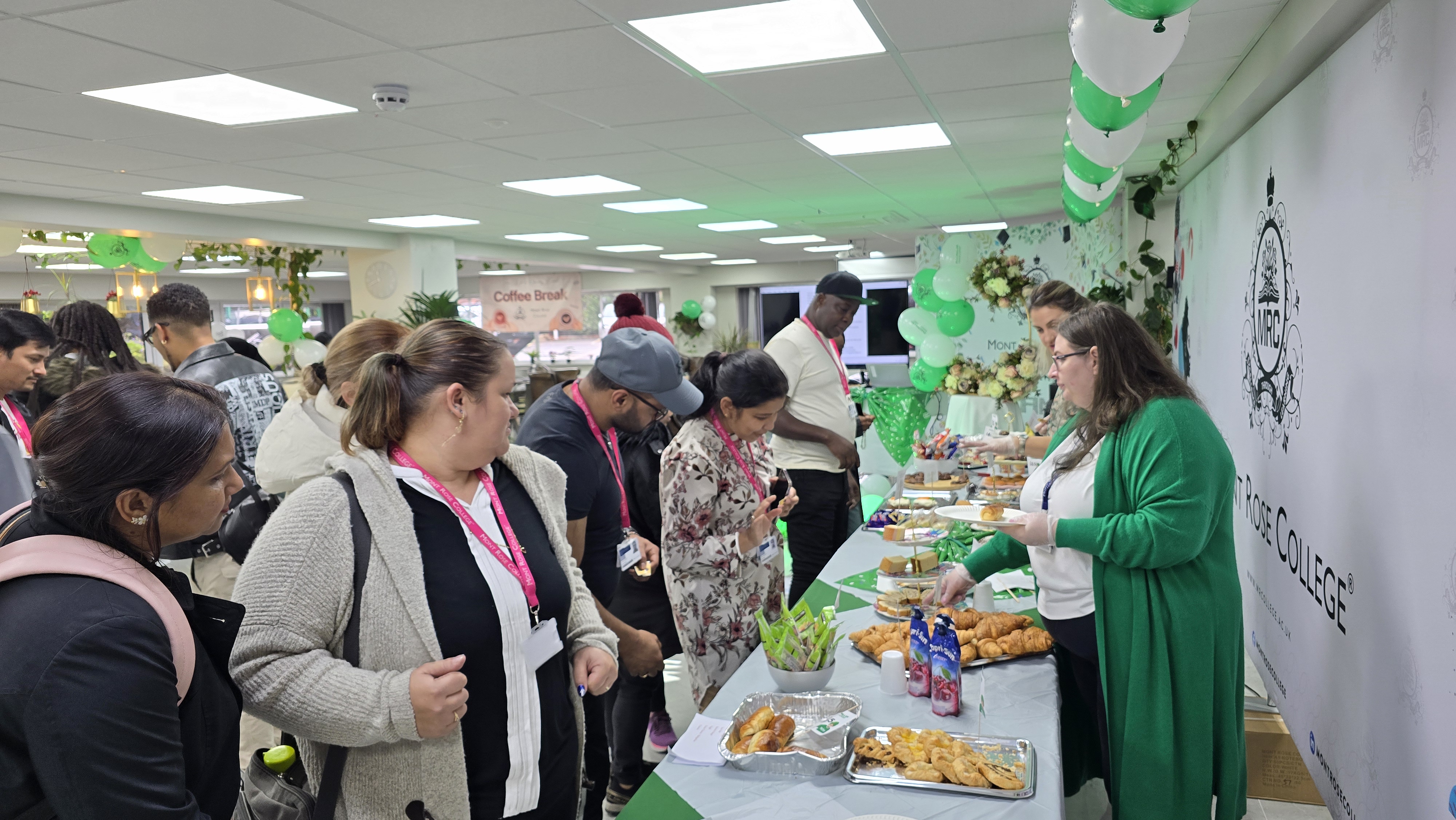 Guests enjoy refreshments at the Mont Rose College Macmillan Charity Event, featuring decorated tables and green-themed decor.
