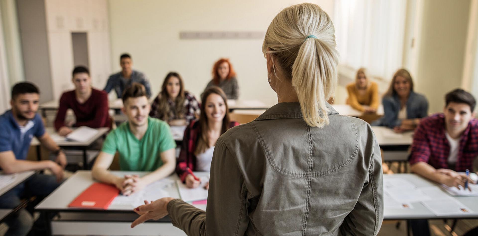 A classroom setting with a teacher addressing attentive students, representing an interactive learning environment while exploring pathways like HNDs vs Apprenticeships.