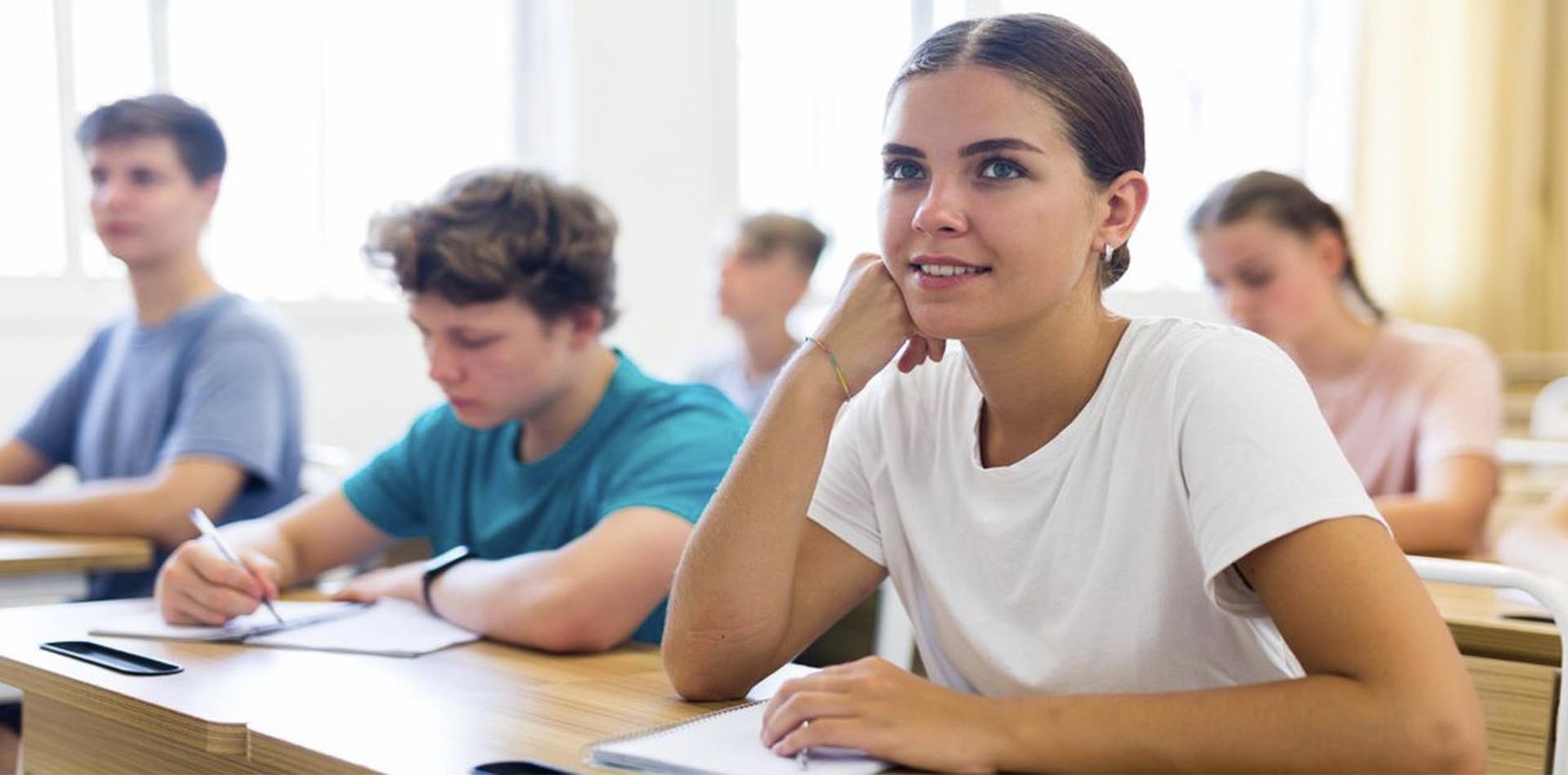 A thoughtful student in a classroom setting, surrounded by peers focusing on their work, symbolizing learning opportunities and the Global Recognition of HND Qualifications.