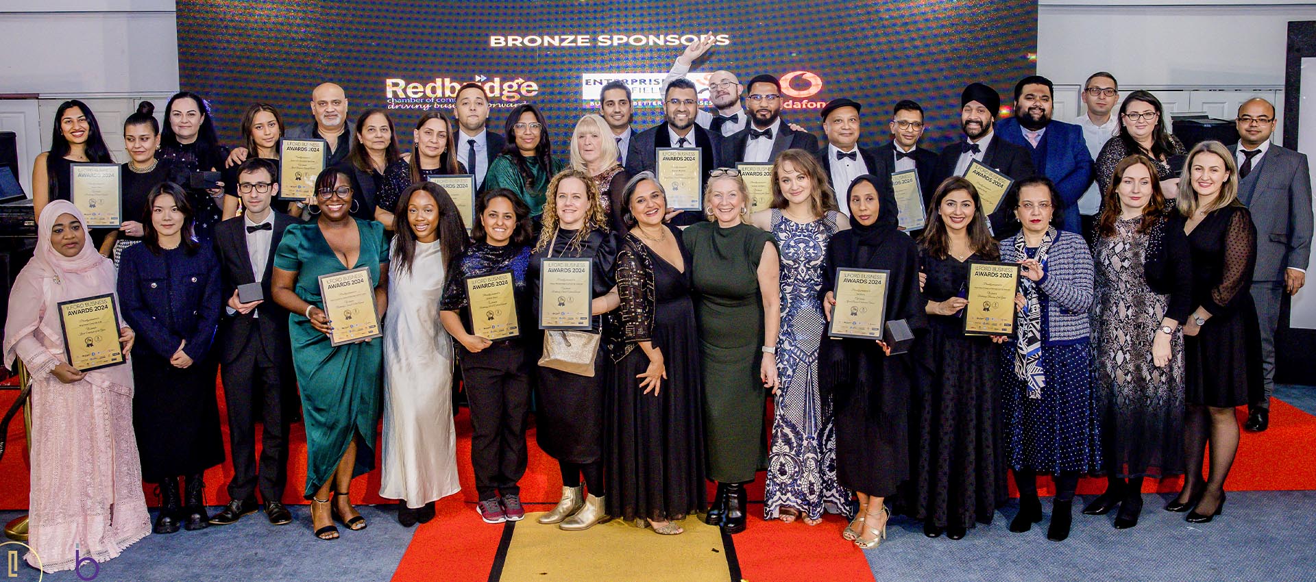 Diverse group of winners at the Redbridge Business Awards 2024, proudly holding certificates and celebrating excellence in business achievements.