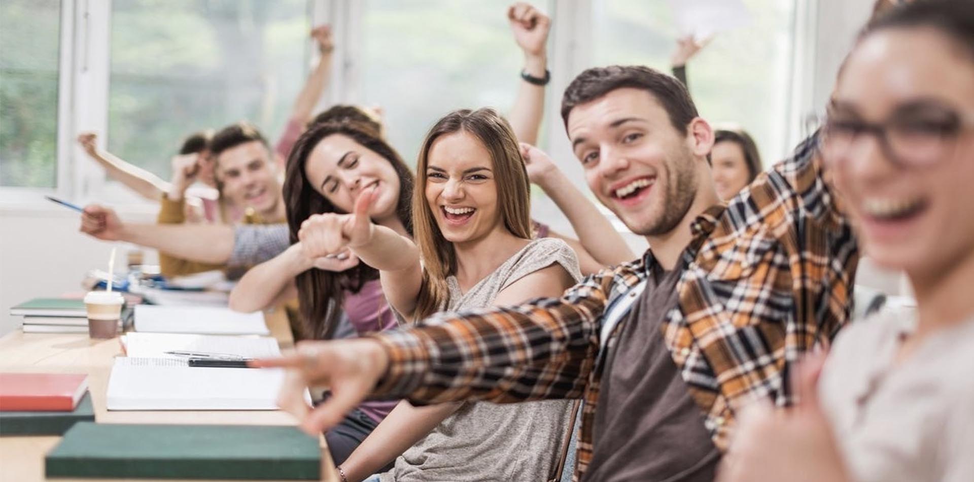 Excited students in a classroom celebrating success, symbolizing opportunities and pathways after completing an HND program.
