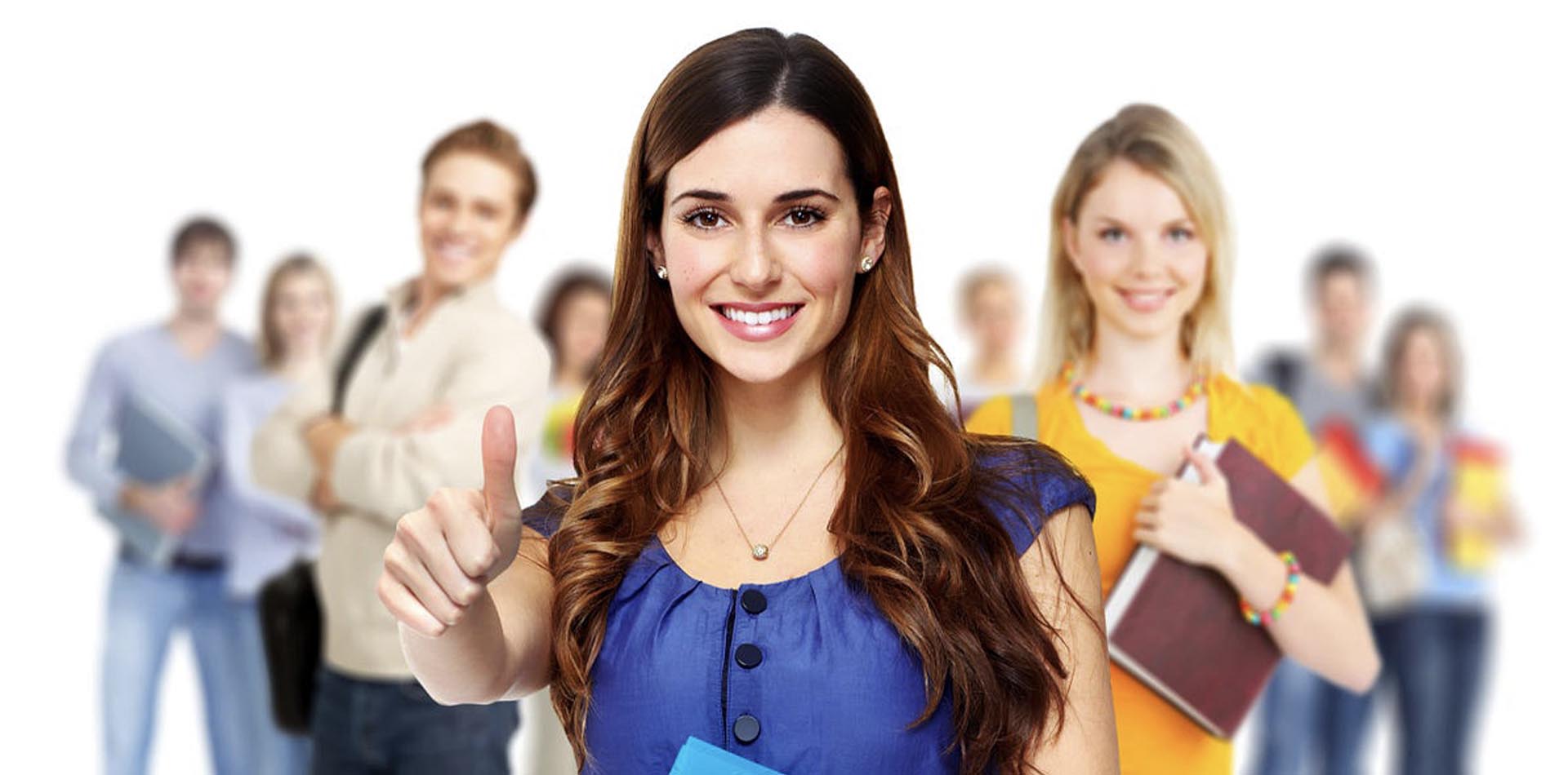 Smiling student giving a thumbs-up, representing confidence in pursuing pathways after completing an HND Program, with peers holding books in the background.