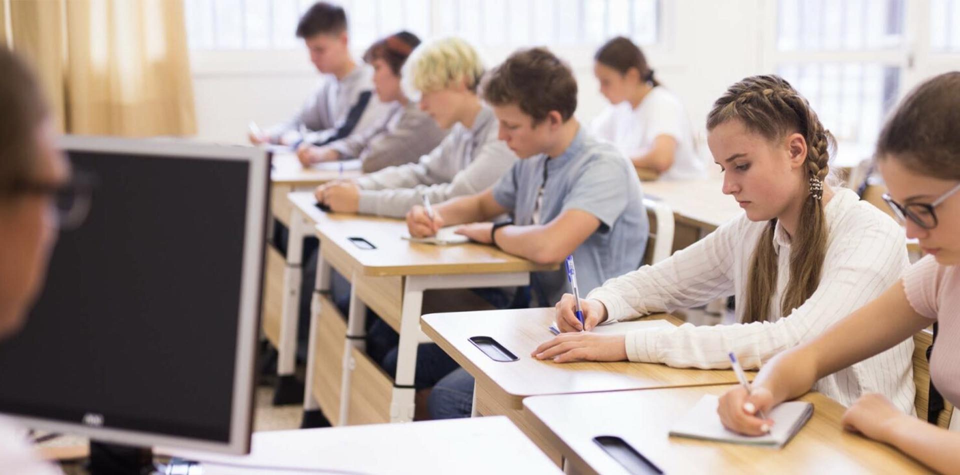 Students seated in a classroom writing notes during an academic session, representing education and study, highlighting the Global Recognition of HND Qualifications.