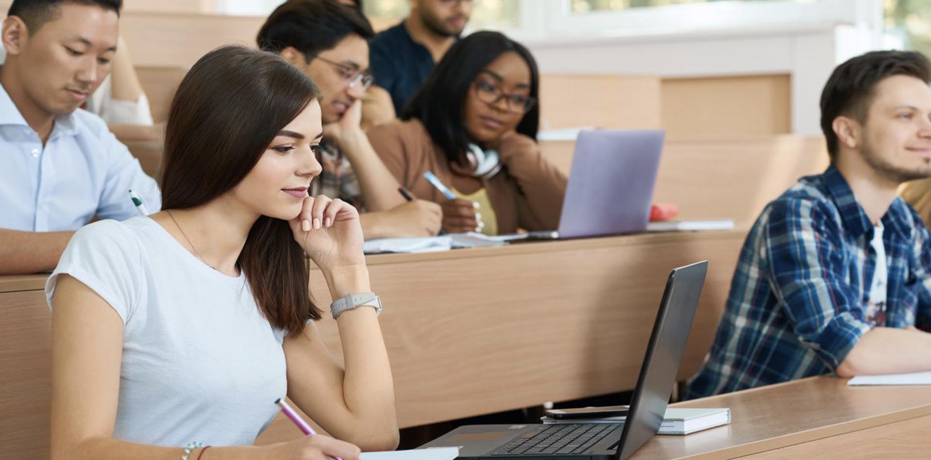 Students taking notes in a lecture hall, actively participating in HND Programs for professional and academic growth.