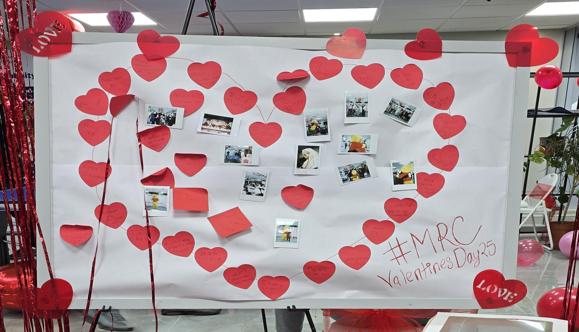 A decorated board with heart-shaped notes and photos, showcasing the Valentine’s Day Celebration at Mont Rose College.