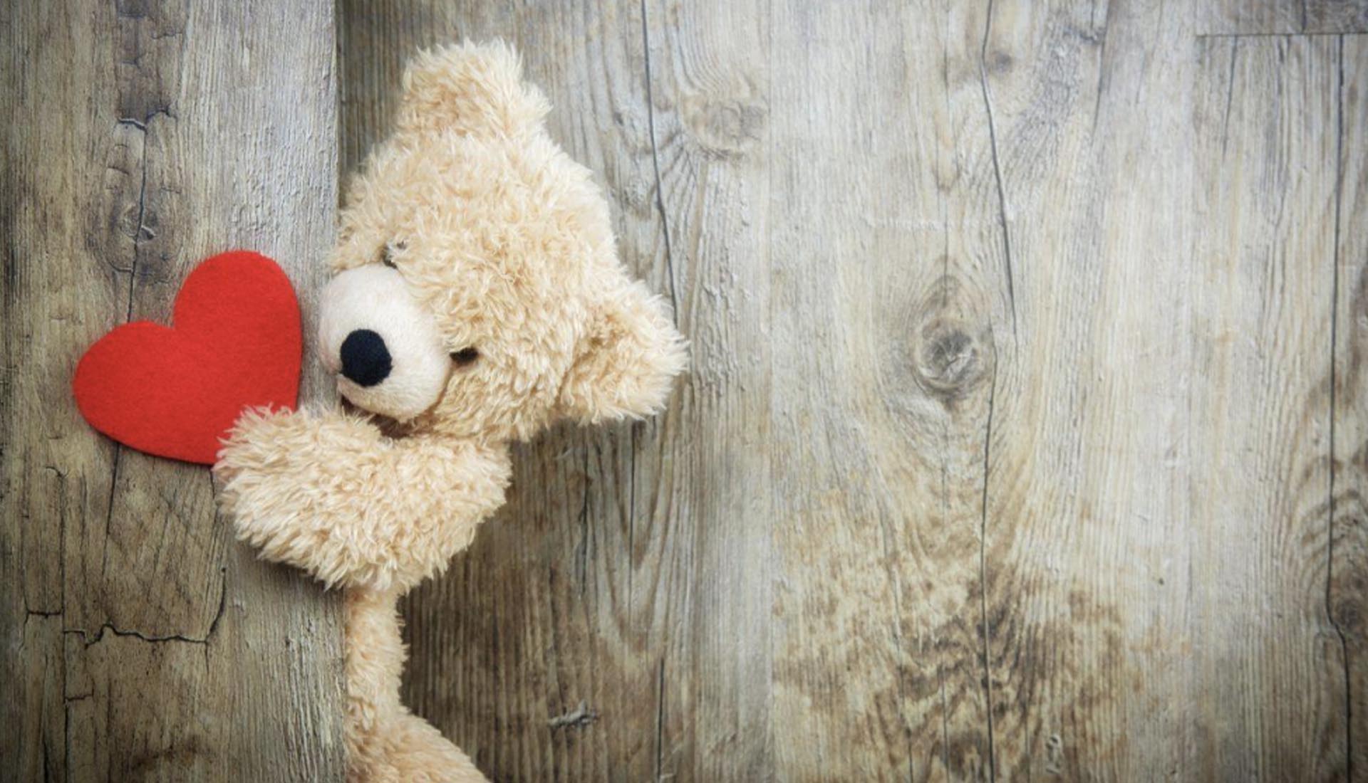 A fluffy teddy bear holding a red heart, symbolizing love and joy for Valentine’s Day Celebration at Mont Rose College.