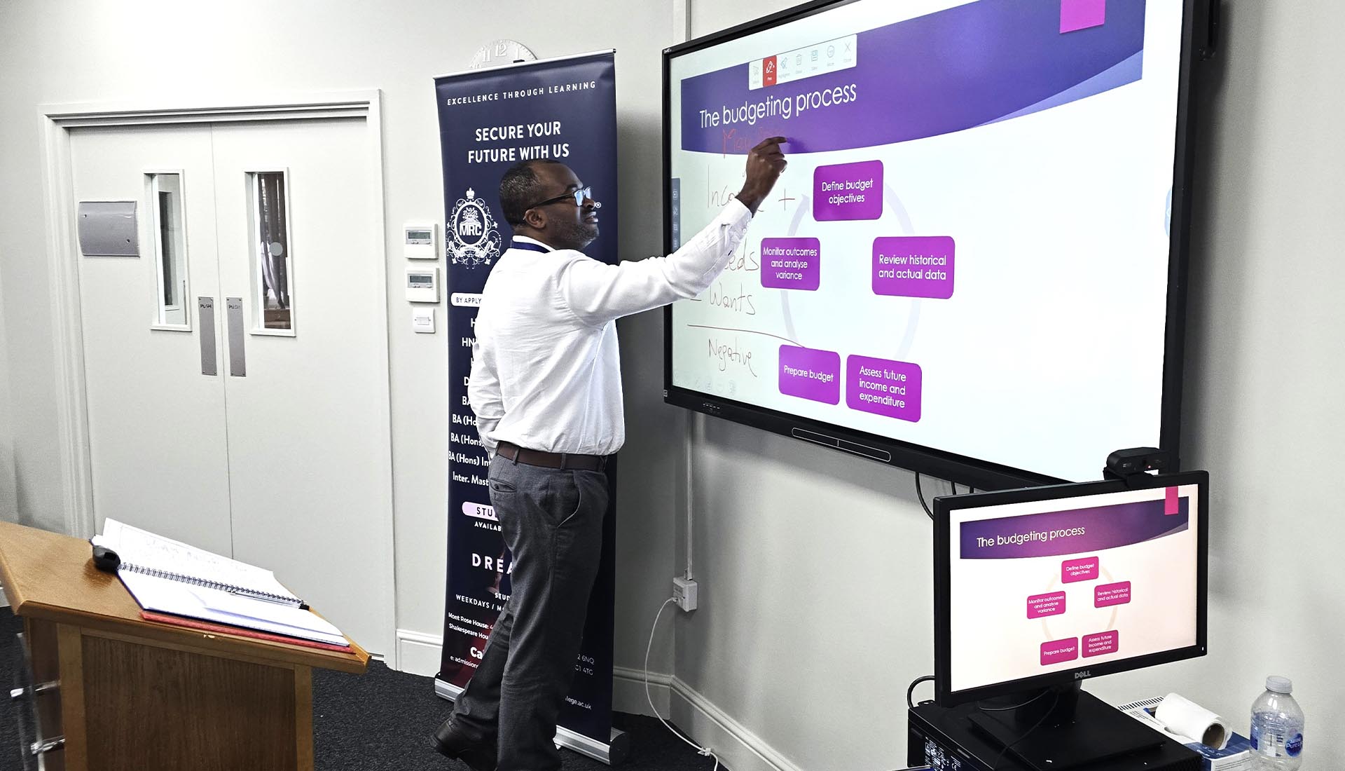 A lecturer explains budgeting at Empowering Financial Futures: Mont Rose College's Financial Capabilities Workshop, enhancing students' financial literacy skills.
