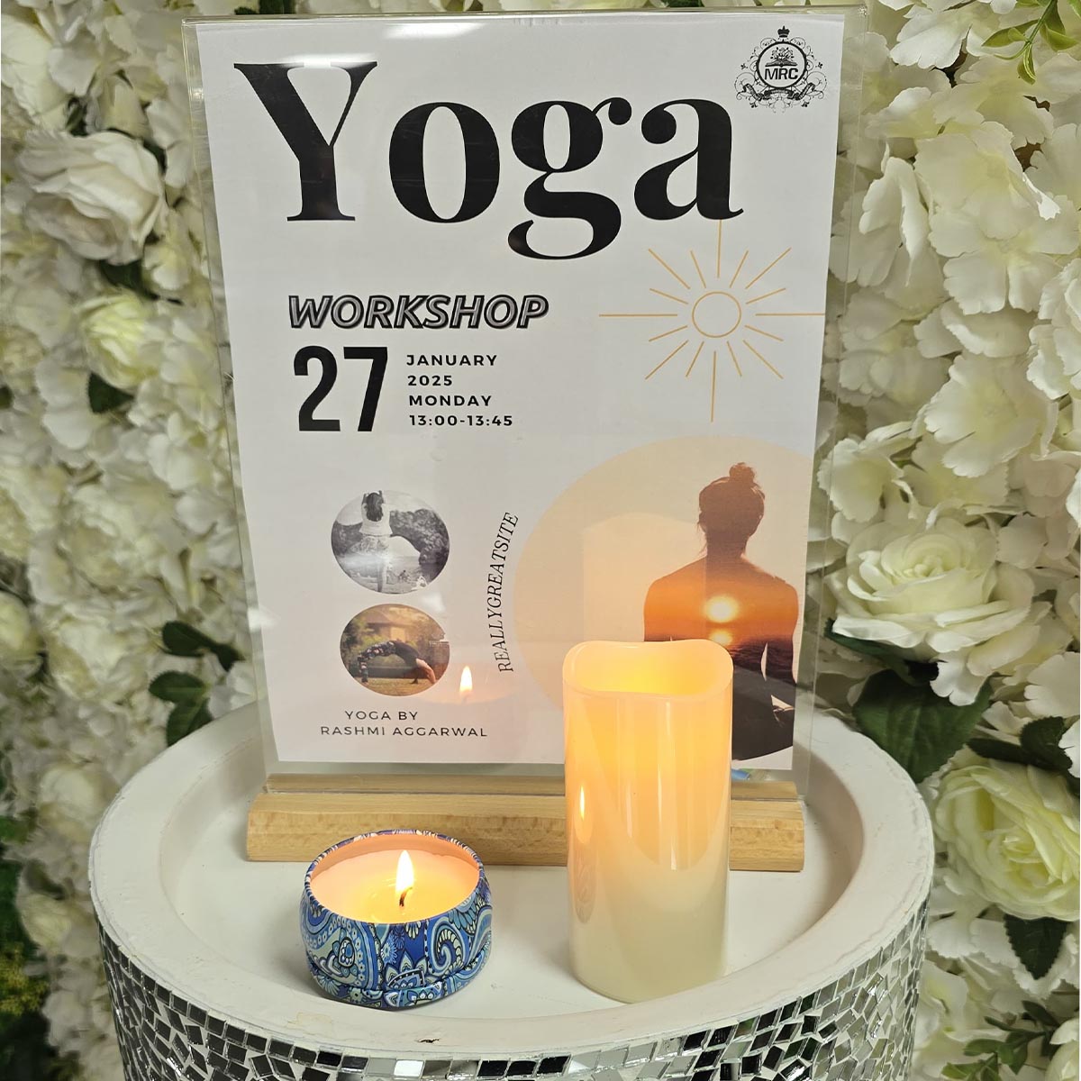 A serene setup with candles and a flyer promoting Yoga at Mont Rose College, scheduled for January 27, 2025.