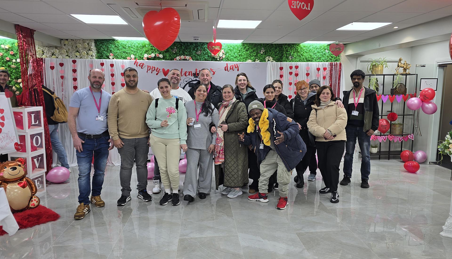 Students and staff enjoying Valentine’s Day Celebration at Mont Rose College, posing in a decorated space with heart balloons and festive decor.