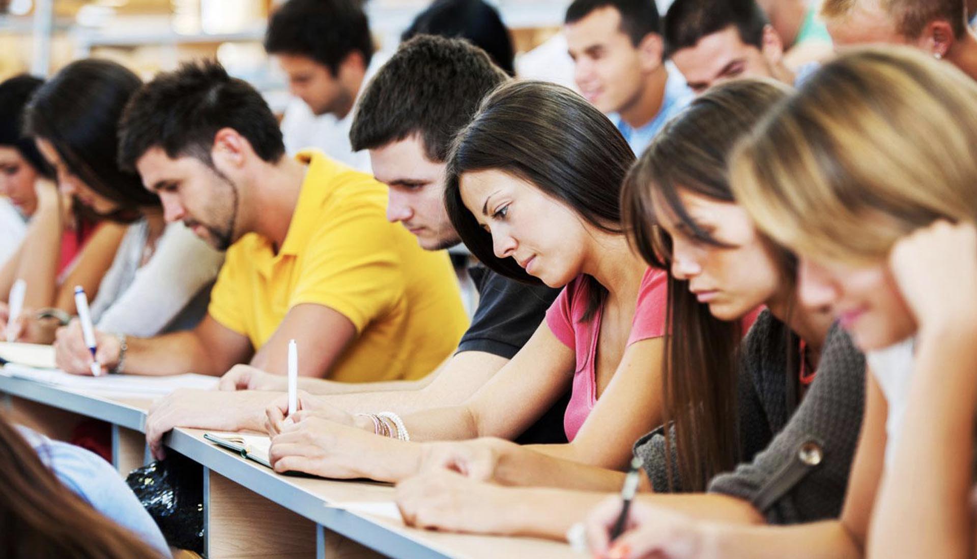 Students attentively taking notes in a classroom during an HND Course, focusing on their studies for academic success.