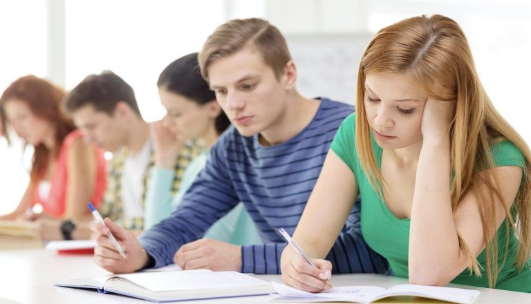 Students studying in a classroom writing in notebooks Opportunities for Further Study After An HND