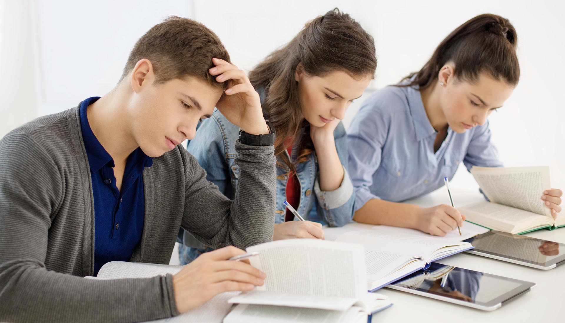 Students studying with books and tablets, highlighting the Affordability of HND Courses and accessible education options.