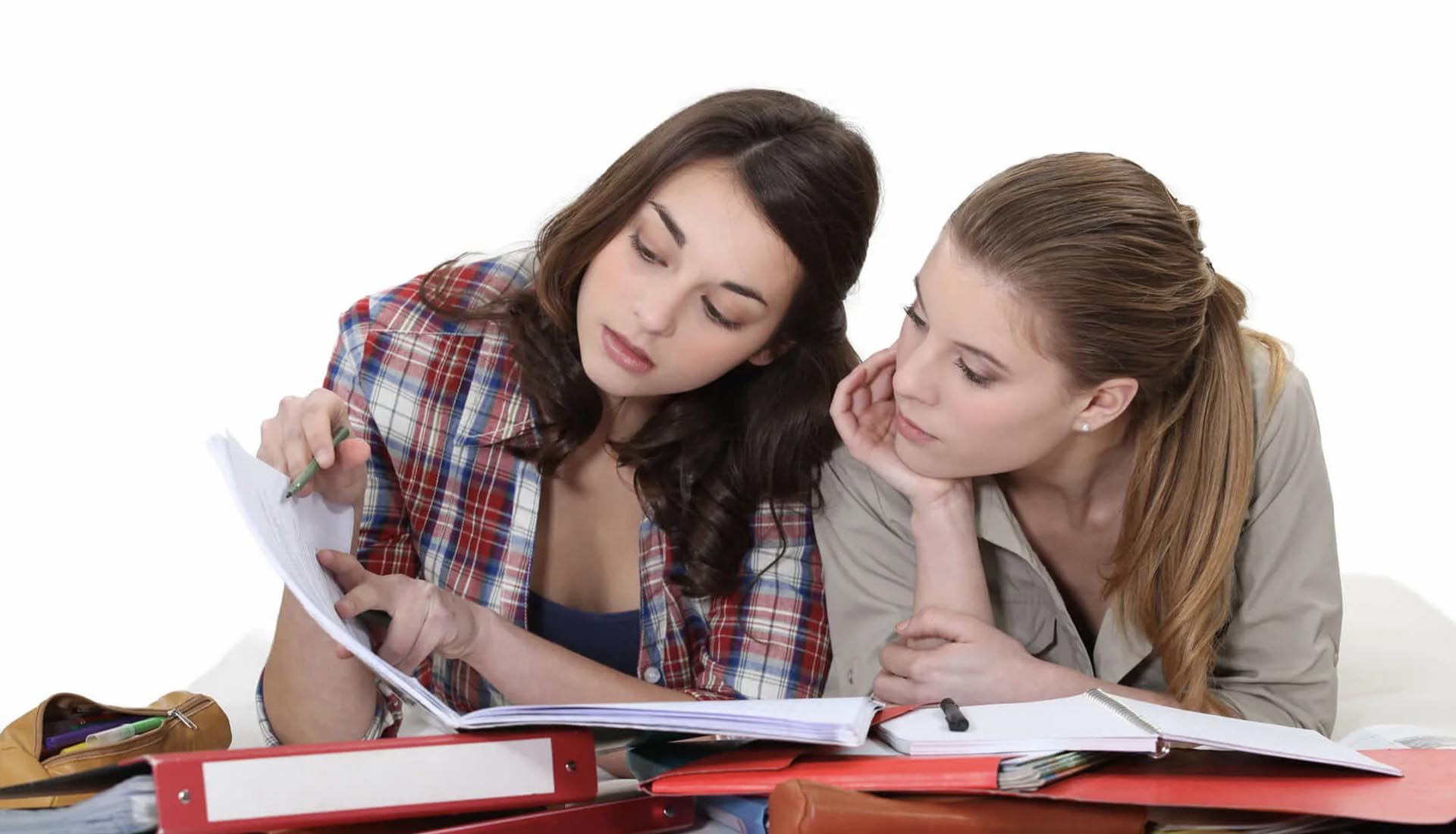 Two students studying together with notebooks and binders, emphasizing the value of HND Qualifications for academic success.