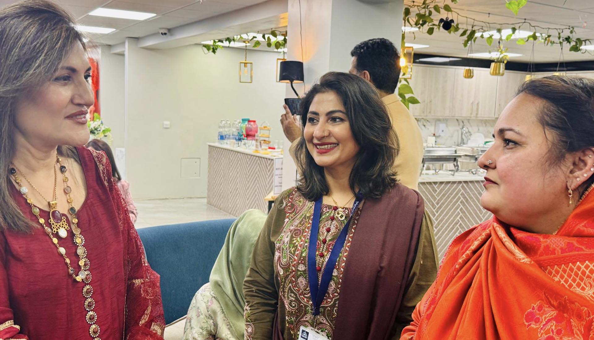 Women in traditional attire smiling and conversing at Celebrating International Women’s Day at Mont Rose College, honoring achievements and empowerment.