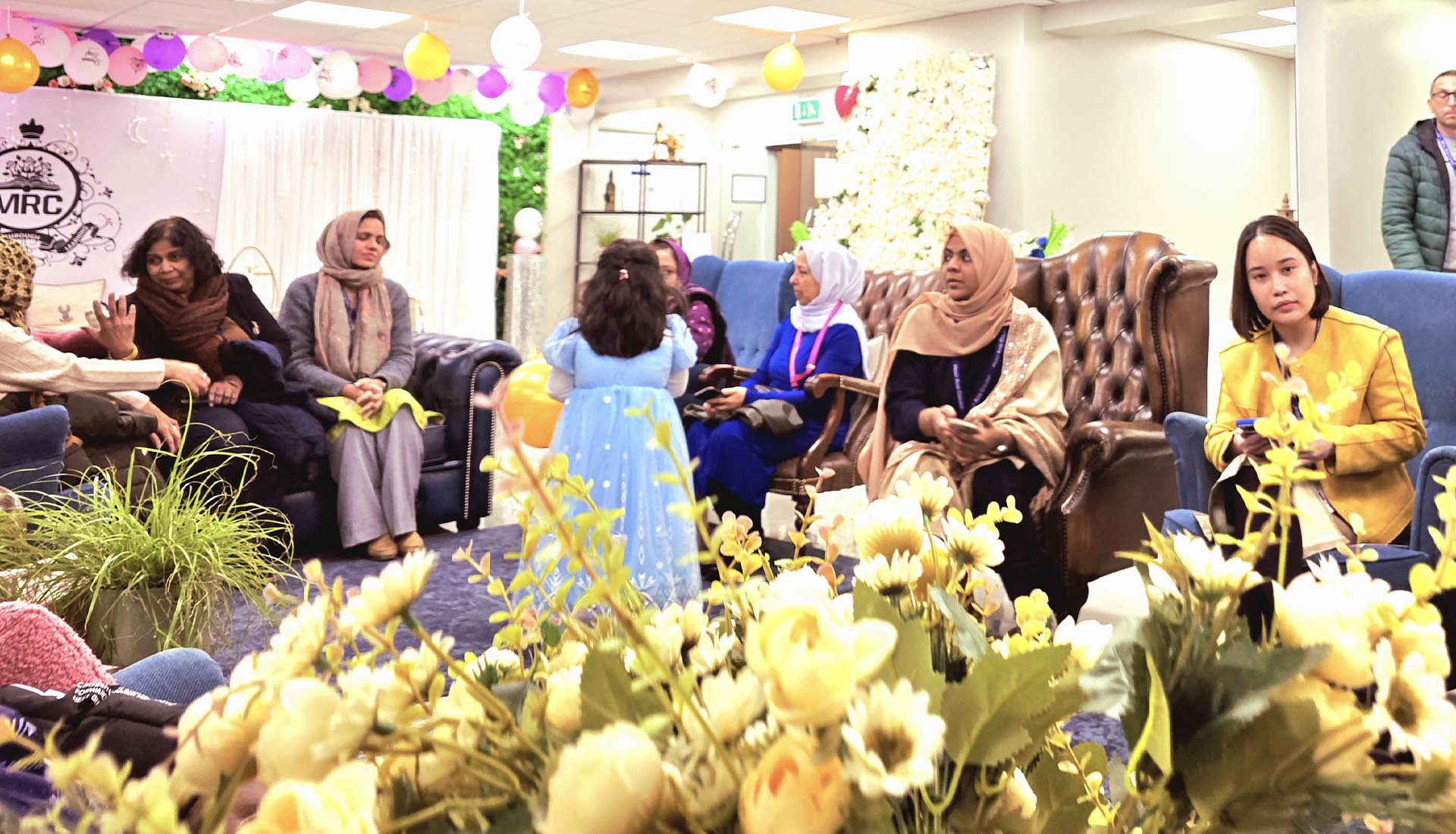 Guests gathered in a warmly decorated venue for the Iftar Dinner at Mont Rose College, engaging in conversations and celebrations.