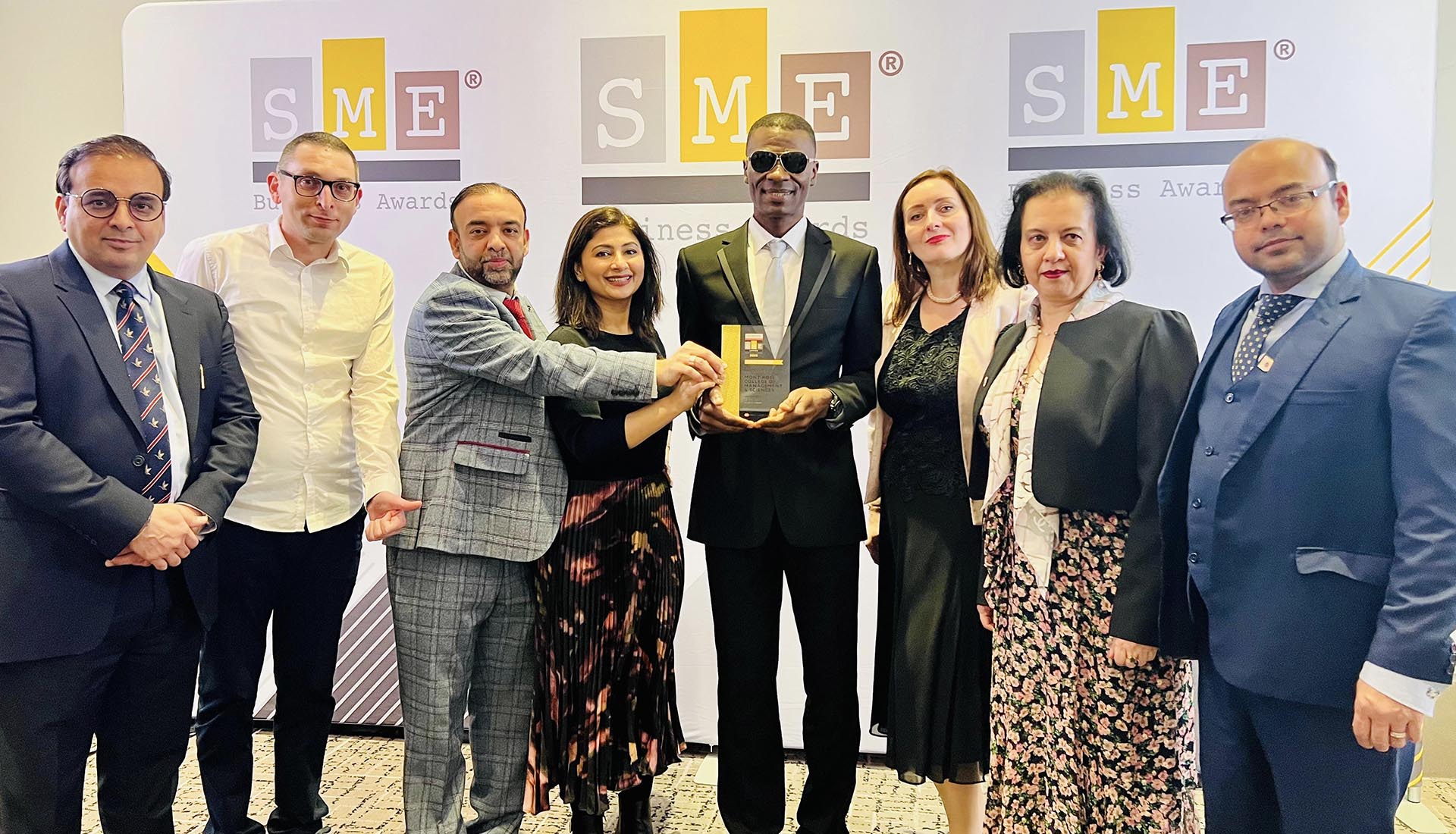 Mont Rose College representatives celebrating their achievement at the SME London Chamber of Commerce Awards, holding a prestigious award.