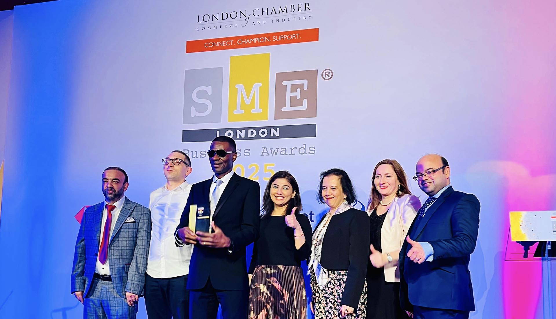 Mont Rose College team celebrating their success at the SME London Chamber of Commerce Awards 2025, posing with their award on stage.