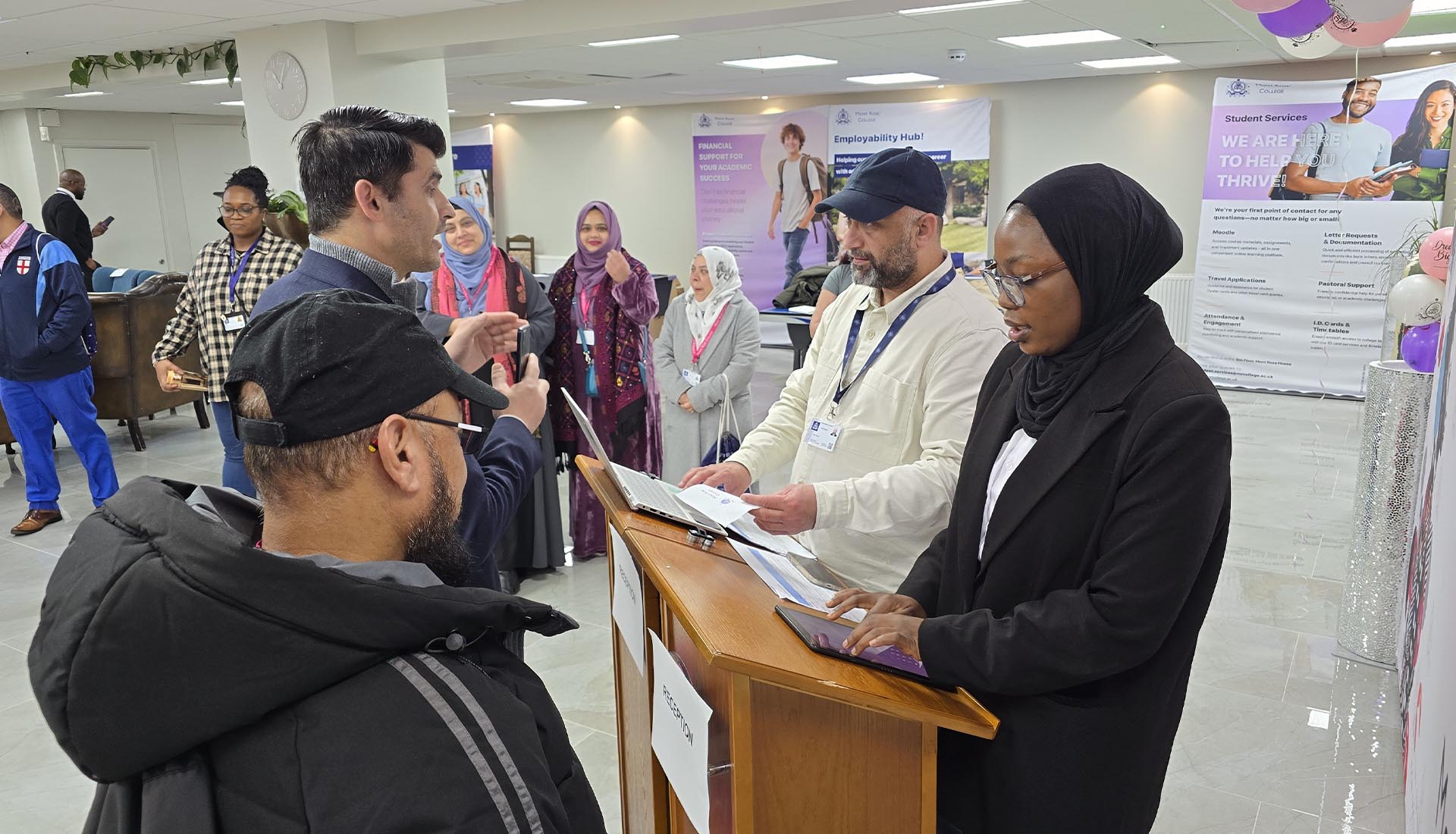 Students interacting at a reception desk setup during a Hospitality Practical Workshop at Mont Rose College.