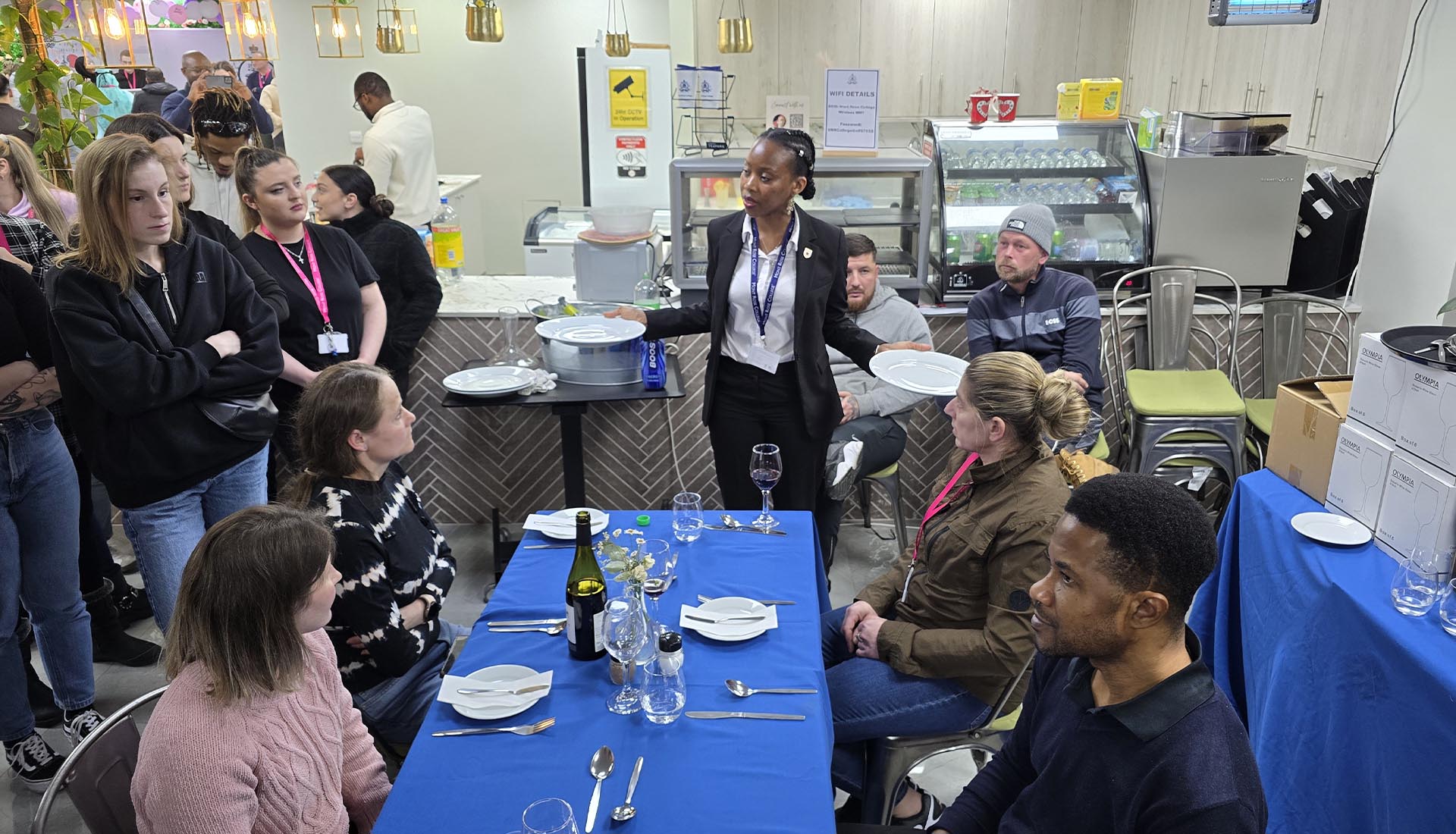 Students observe a Hospitality Practical Workshop demonstration on table setting and service at Mont Rose College.