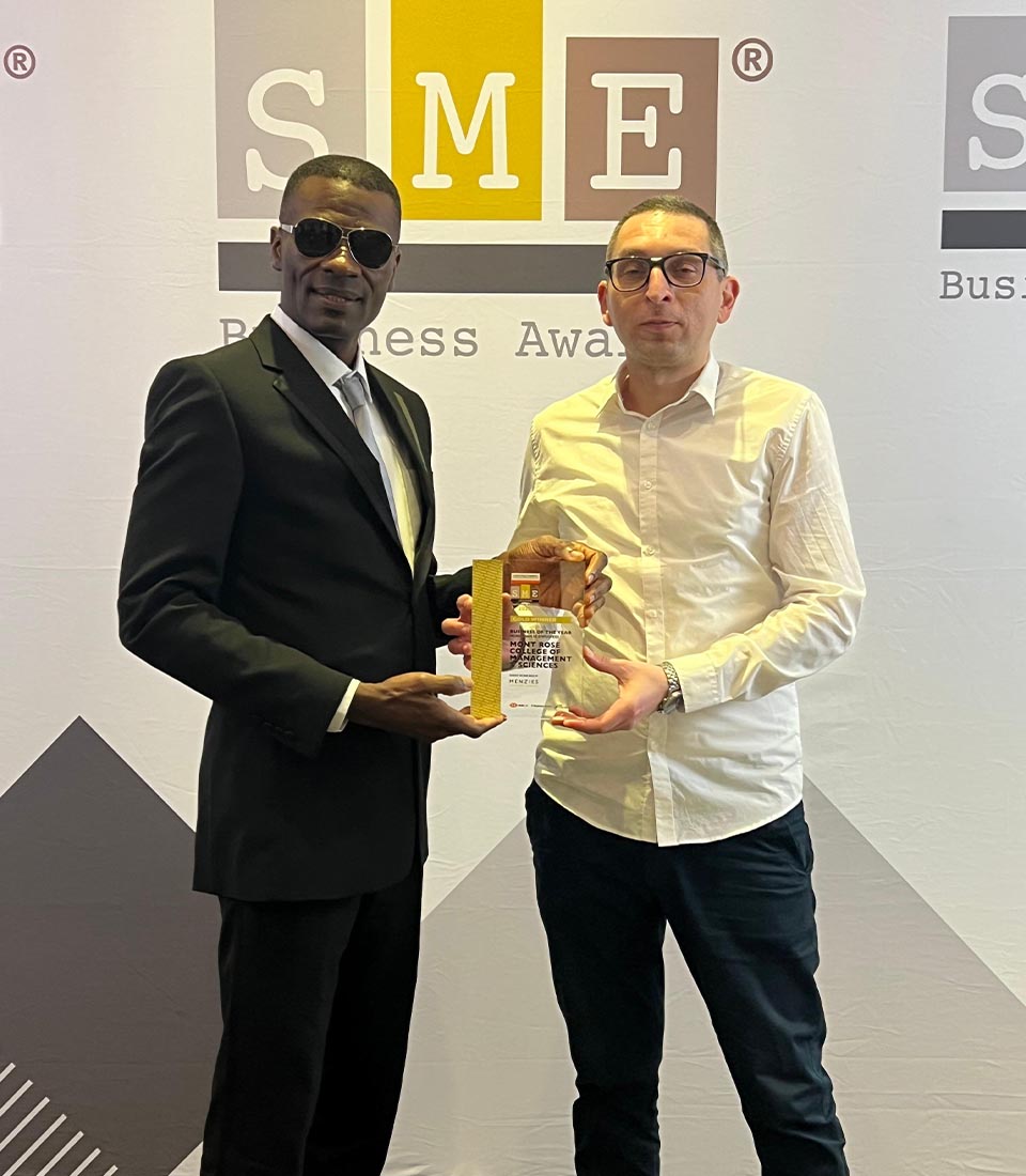 Two men proudly holding an award at the SME London Chamber of Commerce Awards, standing in front of the event backdrop.