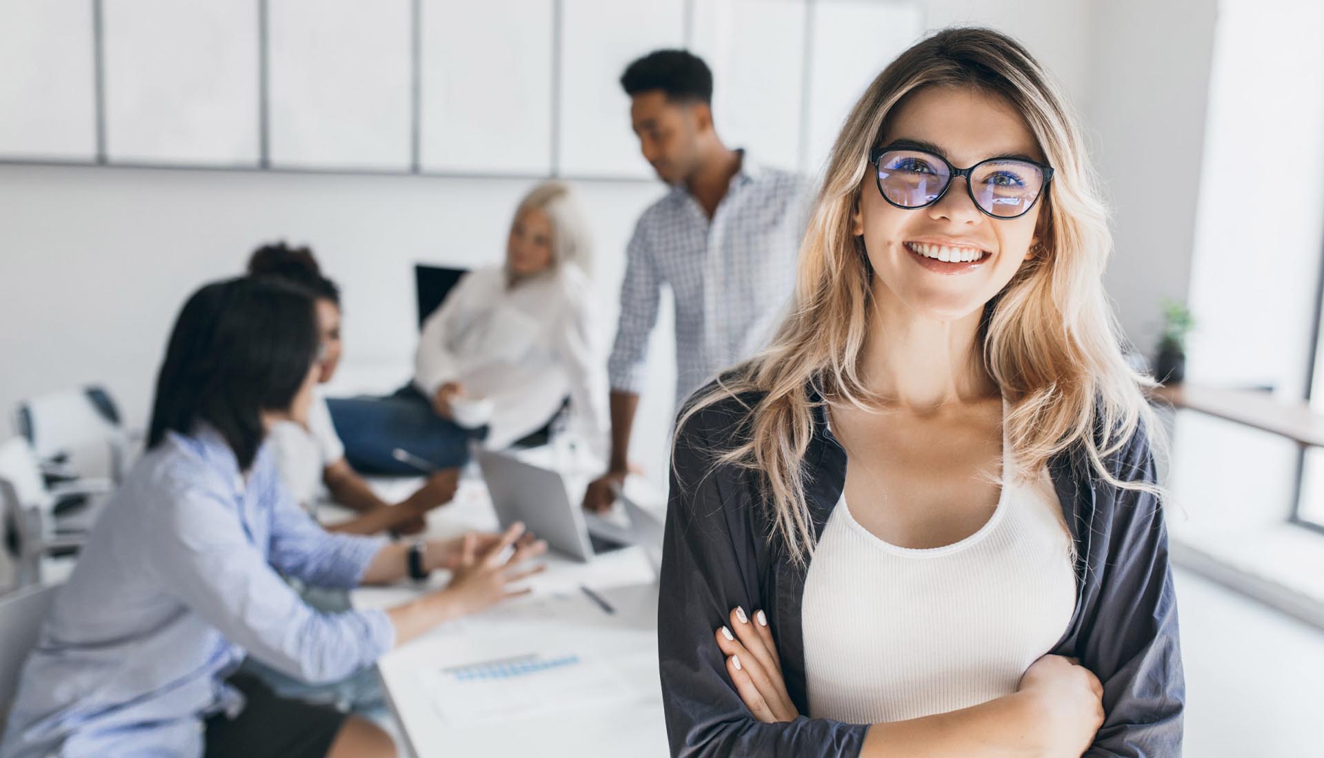 Smiling student in foreground with group discussion behind, representing industry relevant curriculum in HND courses.