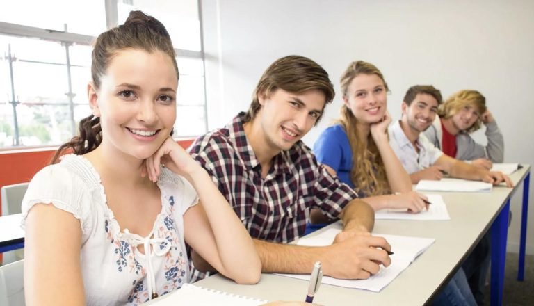 Group of smiling students seated in a classroom, representing the comparison topic HND vs Certificates.