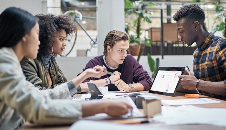Students gathered around a tablet, engaged in a discussion about HND career goals and future opportunities.