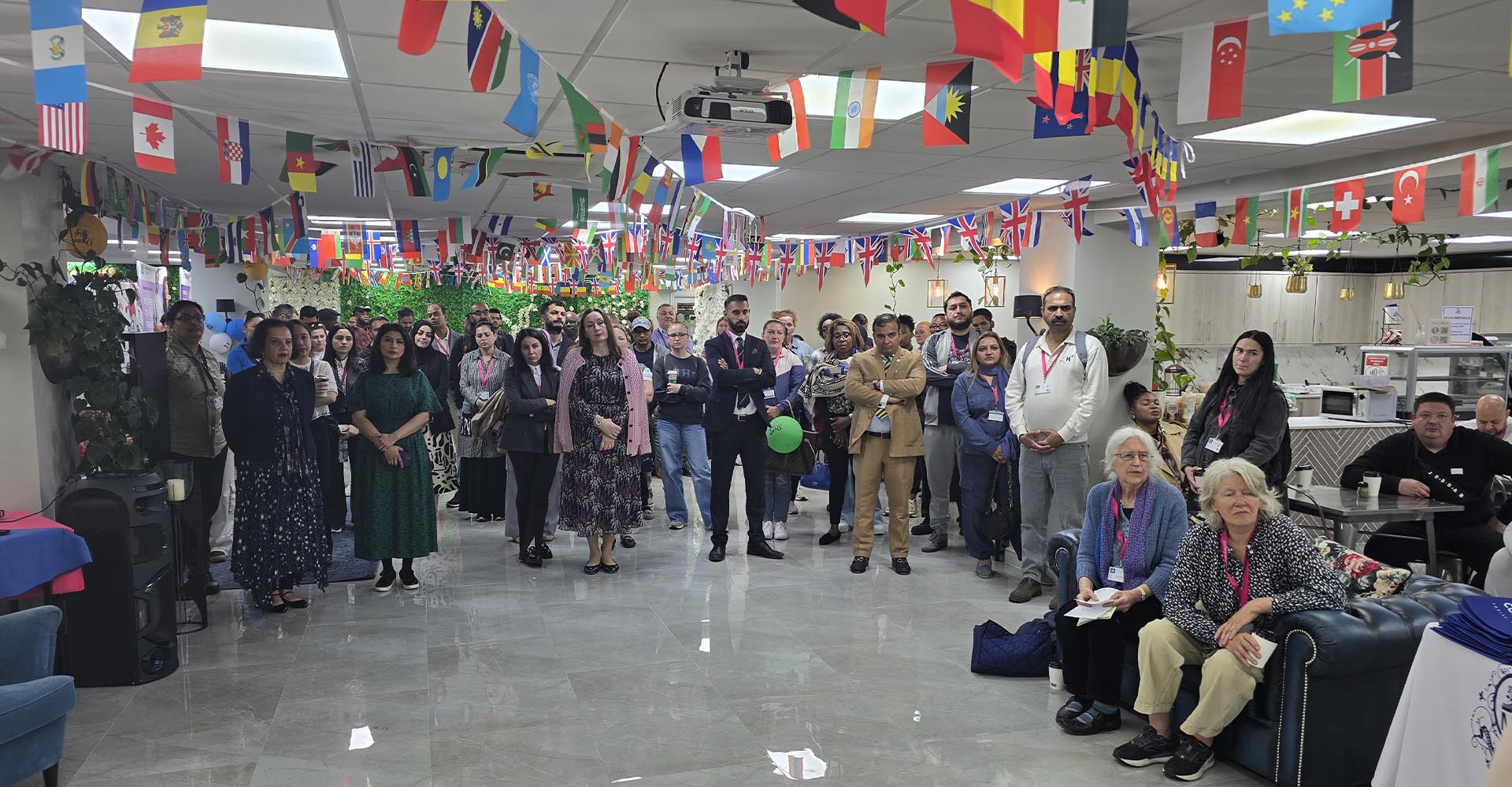 Attendees gathered in a decorated hall with international flags for Mont Rose College’s Environment Day Programme event.