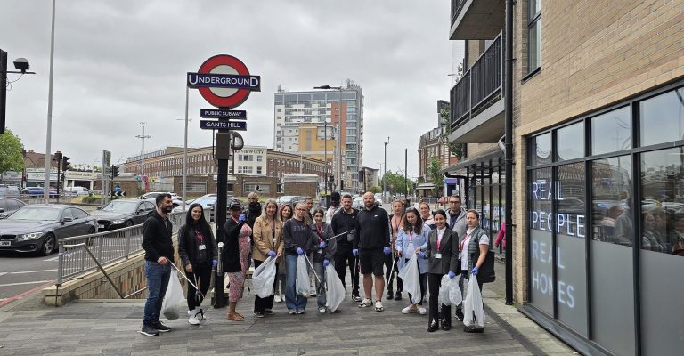 Group of volunteers holding litter pickers and bags near Gants Hill station, participating in Environment Day cleanup activity.
