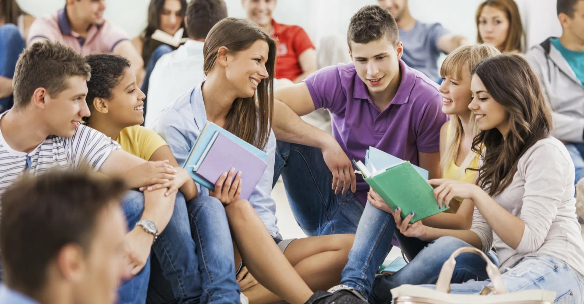 Students sitting in a group discussing books and smiling, reflecting on academic options like HND vs bachelor’s degree.