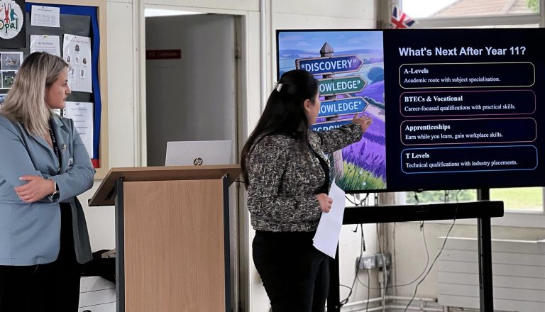 Two women presenting post-Year 11 pathways slide, discussing Higher Education options including A-Levels, BTECs, and T Levels.