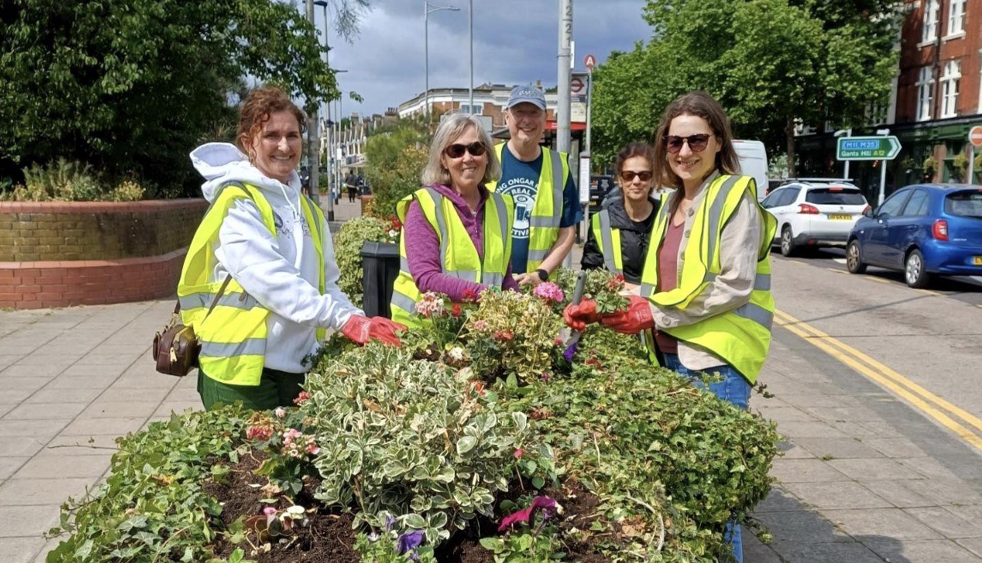 Volunteers planting flowers on a city street, supporting the Greener Redbridge community environmental initiative.