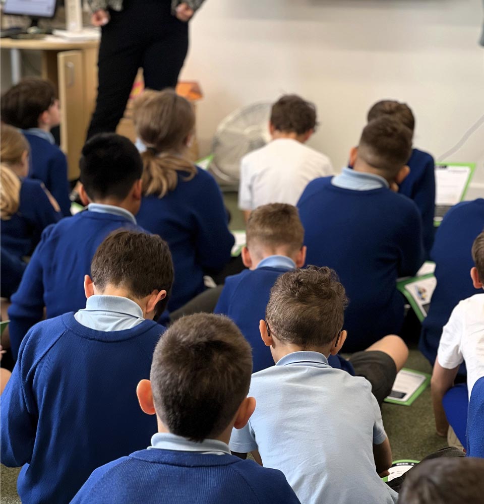 Young students seated on the floor in a classroom, engaging in a session about future goals and Higher Education pathways.