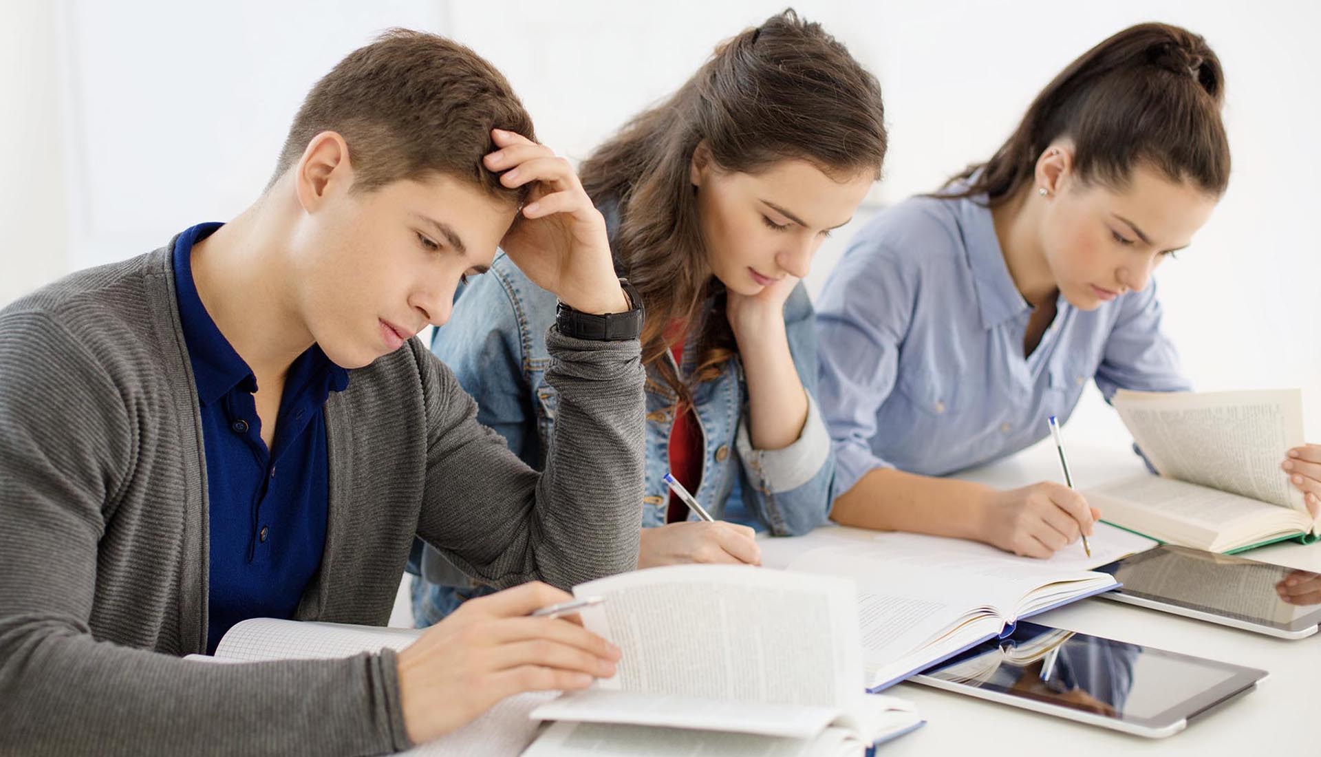 Focused students studying with books and tablets, representing academic commitment in HND and Part-Time Degree programs.