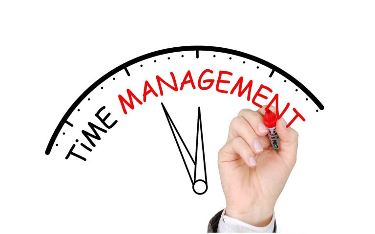 Hand writing “Time Management” on a clock graphic, symbolizing the concept of effective time management.