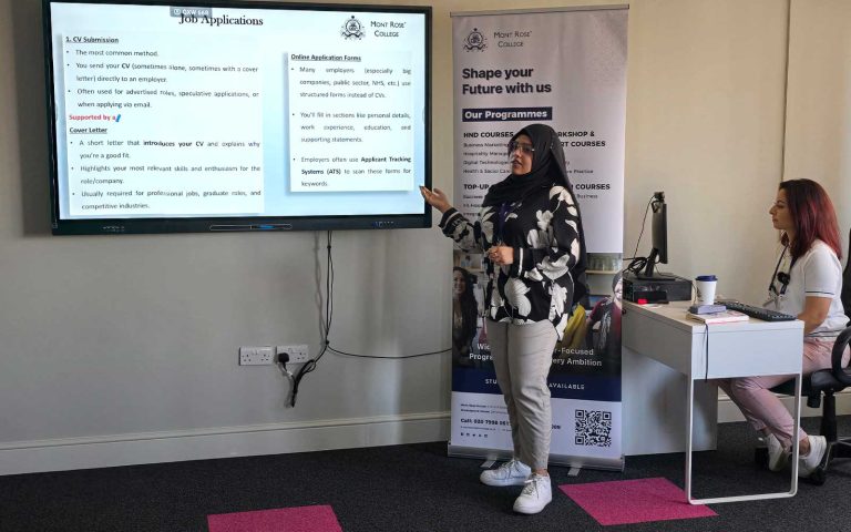 Presenter explaining job application methods during Mont Rose College Career Pathway Workshop with attendee listening attentively.
