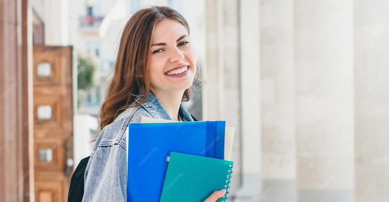 Smiling student holding notebooks outdoors, symbolizing academic readiness for HND Entry Requirements
