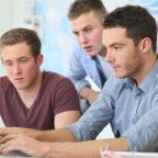 Group of focused students working together on a laptop, representing HND entry requirements for part-time students.