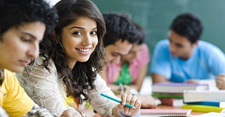 Smiling student in classroom with peers studying, representing HND entry requirements in higher education settings.