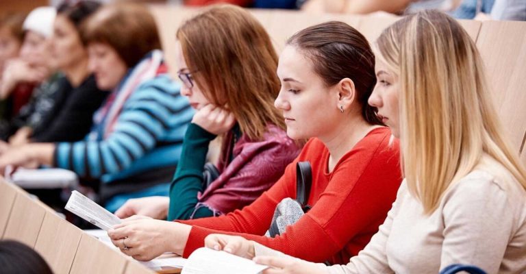 Students attentively reading course material in a lecture hall, representing active participation in an HND creative course.